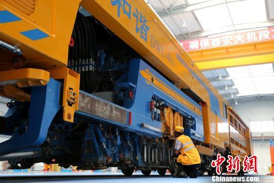 圖為工人正在清理大型養(yǎng)路機(jī)械?！堖h(yuǎn) 攝